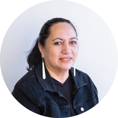 Georgina is a Māori woman. She has her long, dark hair pulled back in a pony tail. . 