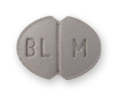 An oval grey pill, with indents on the longer edge. A centre score and the letters BL M etched on it