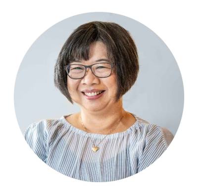 An Asian woman with great short bob hair cut. She is wearing a nice white top with navy pin stripes.. 