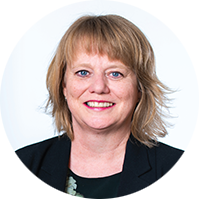 Sarah Fitt, a Pākeha woman, smiles at the camera warmly. She has blonde medium length hair.. 