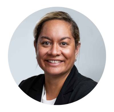 A Māori woman with her hair pulled back behind her head. She is wearing a blazer.. 